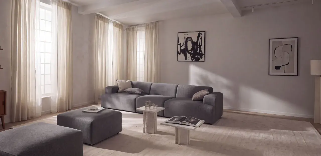 Nowoczesny salon z szarą sofą i pufami, inspiracja jak uzyskać kolor grafitowy w aranżacji.