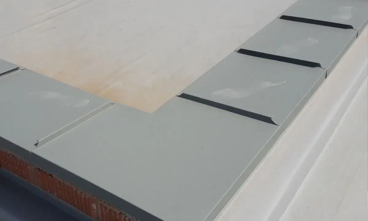 Szary parapet dachowy, element montażu rynien plastikowych, zabezpiecza mur przed wilgocią.