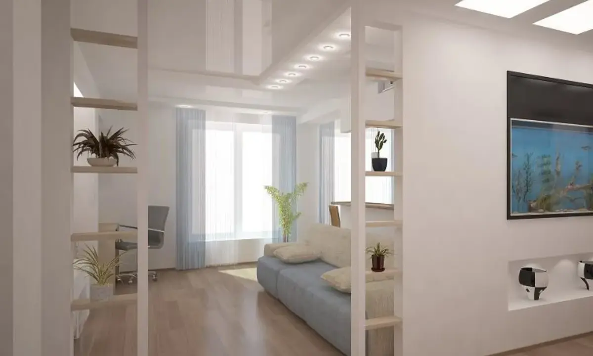 Otwarta przestrzeń z sofą i akwarium. Półki w ściance działowej to świetny pomysł na przechowywanie i dekorację.