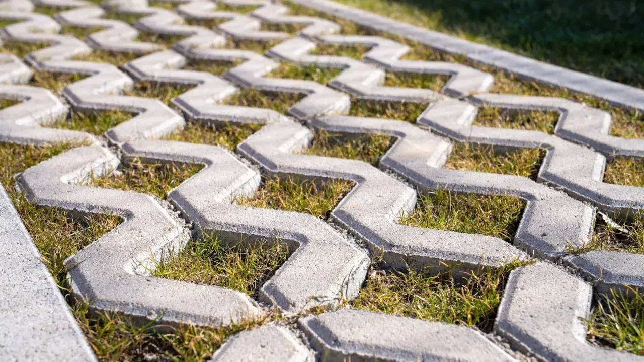 Szary beton na płyty ażurowe, z trawą rosnącą między elementami. Idealny na podjazd.
