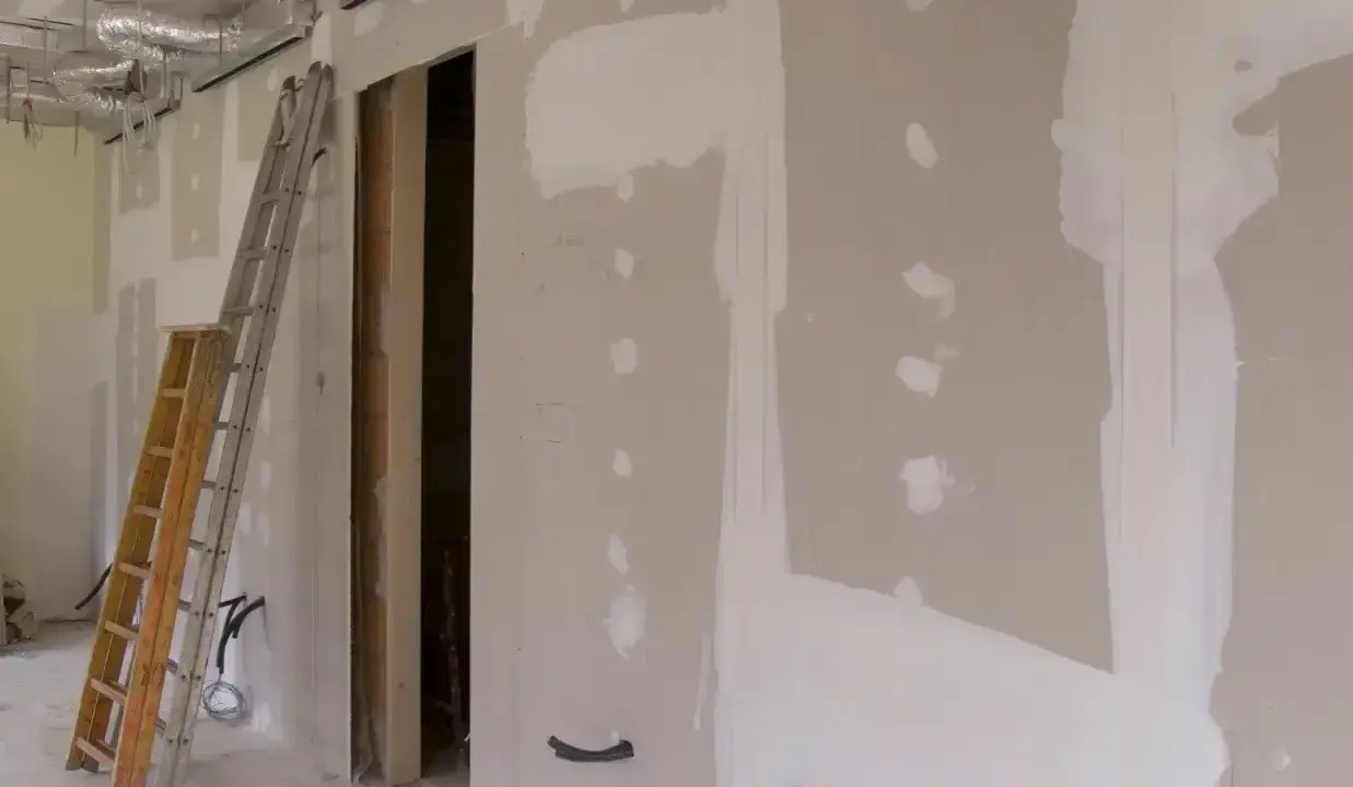 Budowa wnętrza z widocznymi ciekawymi zabudowami z płyt gipsowych, drabiną i instalacjami.
