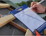 Rysunki na notesie pokazują, jak wymierzyć dach kopertowy. Obliczenia na papierze pomagają w pracach dekarskich.