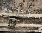 Wilgotny sufit garażu nieogrzewanego, z widoczną lampą przemysłową i śladami pleśni. Jaki tynk do garażu nieogrzewanego sprawdzi się w takich warunkach?