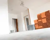 Materiały budowlane, w tym cegły, czekają na remont. Wnętrze domu w trakcie prac, przygotowanie do tego, jak wyrównać ściany w starym domu.
