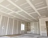 Sufit z płyt karton gips bez stelaża, przygotowany do wykończenia. Widać pionowe połączenia na ścianach.