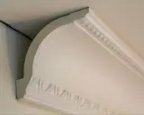 Widok z bliska na narożnik sufitu z elementami dekoracyjnymi i widocznym stelażem pod karton gips sufit.