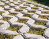 Szary beton na płyty ażurowe, z trawą rosnącą między elementami. Idealny na podjazd.