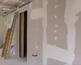 Budowa wnętrza z widocznymi ciekawymi zabudowami z płyt gipsowych, drabiną i instalacjami.