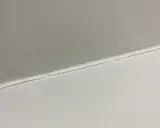 Pęknięcie na ścianie, które wygląda jak linia, jakby ktoś narysował je cienkim flamastrem. Czy to flizelina czy siatka?