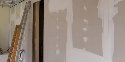 Budowa wnętrza z widocznymi ciekawymi zabudowami z płyt gipsowych, drabiną i instalacjami.