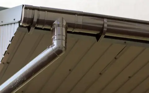 Brązowa rynna 75 mm, idealnie dopasowana do dachu z blachy trapezowej, odprowadza wodę deszczową.