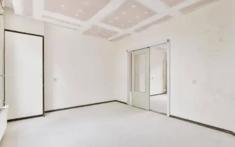Pokój w trakcie remontu, widoczny sufit z płyt gipsowo-kartonowych, gotowy do wykończenia. Dowiedz się, jak wyrównać sufit bez szlifowania.