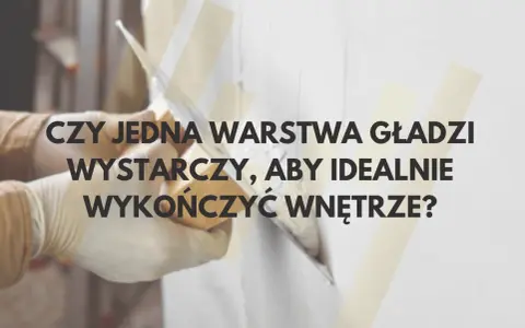 Ręce w rękawiczkach nakładają gładź na ścianę. Czy jedna warstwa wystarczy, by wykończyć wnętrze?