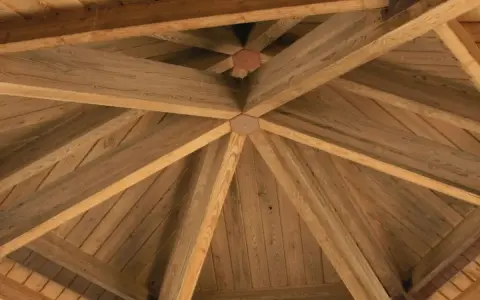 Drewniana konstrukcja dachu altany, idealna jako baza do wyboru, czym pokryć dach altany.