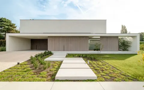 Nowoczesny podjazd do domu aranżacje: betonowe płyty, żwirowa nawierzchnia i minimalistyczna zieleń tworzą eleganckie wejście.