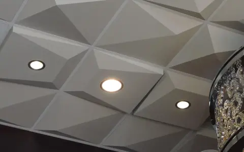 Nowoczesny sufit z geometrycznymi panelami i wbudowanymi punktami świetlnymi. Świetna alternatywa dla kasetonów, nadająca wnętrzu charakteru.