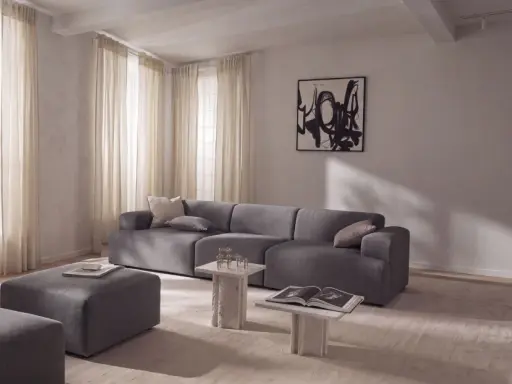 Nowoczesny salon z szarą sofą i pufami, inspiracja jak uzyskać kolor grafitowy w aranżacji.