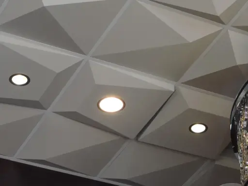 Nowoczesny sufit z geometrycznymi panelami i wbudowanymi punktami świetlnymi. Świetna alternatywa dla kasetonów, nadająca wnętrzu charakteru.