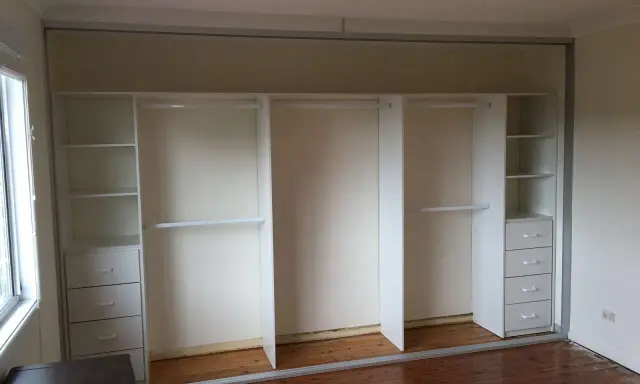 Nowa szafa z karton gipsu z półkami i szufladami, gotowa na ubrania.