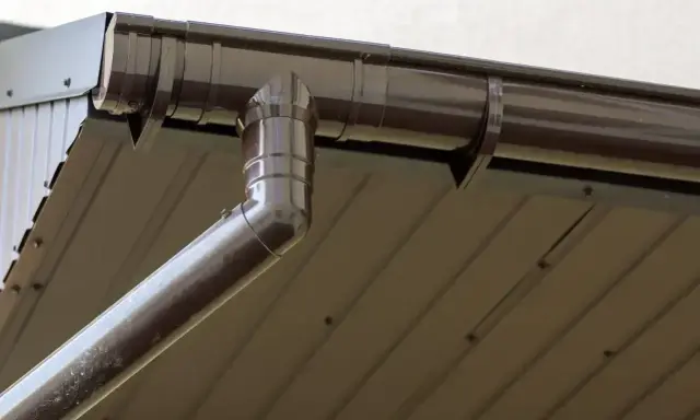 Brązowa rynna 75 mm, idealnie dopasowana do dachu z blachy trapezowej, odprowadza wodę deszczową.