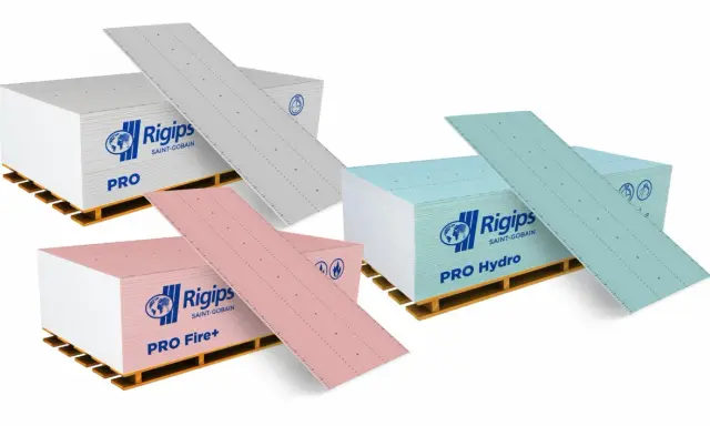 Karton gips do łazienki: zielone płyty Rigips PRO Hydro, różowe PRO Fire+ i szare PRO na paletach.